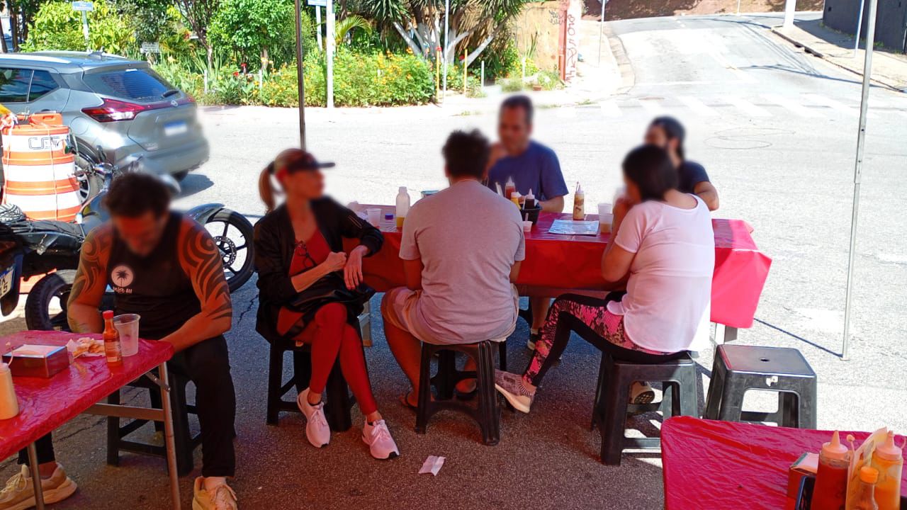 pessoas comendo em grupo na rua