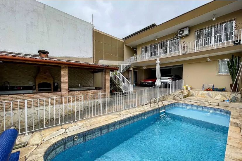 sobrado com carro na caragem e uma piscina externa